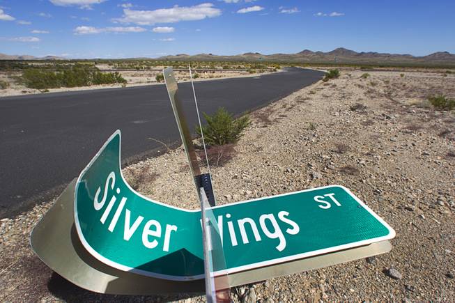 A street sign is shown on the ground in the abandoned Airpark residential development near the Searchlight Airport in Searchlight on Sunday, Sept. 28, 2014.