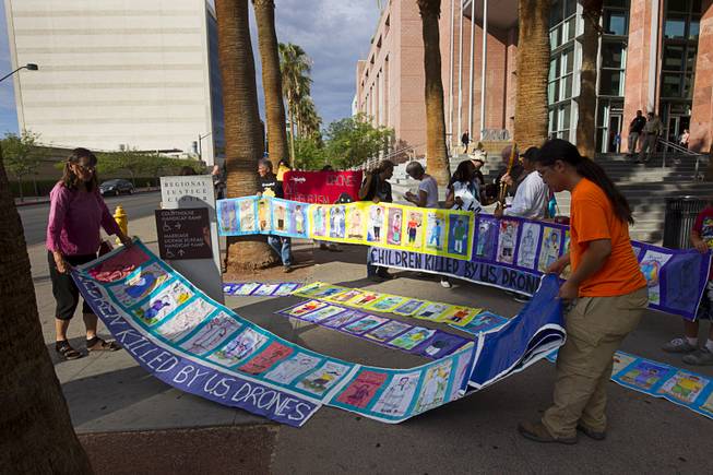 Anti-drone activists place banners with artwork representing children that have been killed in drone strikes during a protest in front the Clark County Regional Justice Center in Las Vegas Tuesday, June 30, 2015. Many of the activists are facing misdemeanor charges in relation to a March 6, 2015 protest at Creech Air Force Base, about 45 miles northwest of Las Vegas.