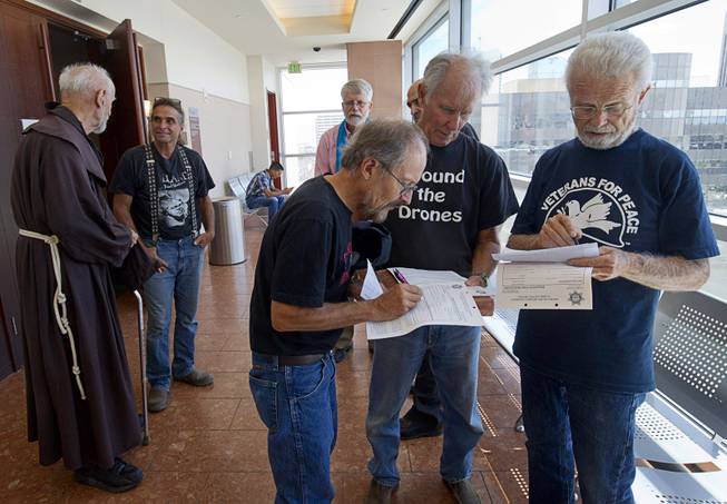 Anti-drone activists confer in a hallway after appearances at the Clark County Regional Justice Center in Las Vegas Tuesday, June 30, 2015. Many of the activists are facing misdemeanor charges in relation to a March 6, 2015 protest at Creech Air Force Base, about 45 miles northwest of Las Vegas.