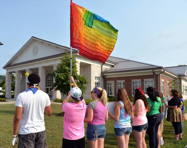 Protesters waive a rainbow flag on the front lawn of the Rowan County Judicial Center, Tuesday, June 30, 2015, in Morehead, Ky. The protest was being held against Rowan County Clerk Kim Davis, who, due to the ruling of the Supreme Court of the United States and her own religious beliefs, has refused to issue any marriage licenses in the county. 