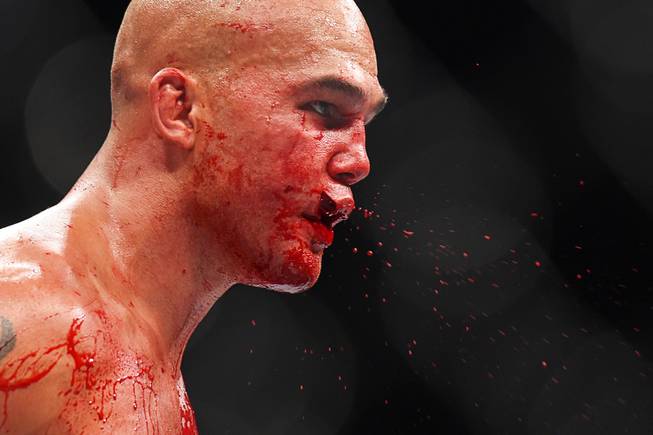 Robbie Lawler spits blood from a split lip during his welterweight title fight against Rory Macdonald at UFC 189 Saturday, July 11, 2015 at the MGM Grand Garden Arena in Las Vegas, Nevada. Lawler won by TKO in the fifth round.