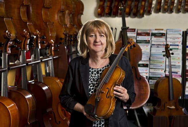 Violin Outlet owner Mara Lieberman amongst some of her prized instruments at the Village Square Commercial Center.