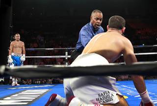 WBA/IBF/WBO light heavyweight champion Sergey Kovalev of Russia waits in a neutral corner as referee Kenny Bayless gives a count to Nadjib Mohammedi of France during their light heavyweight title fight at the Mandalay Bay Events Center Saturday, July 25, 2015. Kovalev won with a third-round knockout.