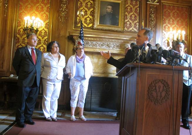Republican Assembly Speaker Robin Vos, right, motions to Democratic Reps., from left: Peter Barca; JoCasta Zamarripa and Christine Sinicki at a news conference to announce a bill to pay for a new $500 million Milwaukee Bucks arena will pass on Tuesday, July 28, 2015, in Madison, Wis.