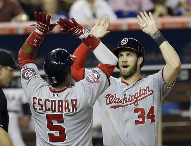 Washington Nationals’ Bryce Harper (34) is congratulated by teammate Yunel Escobar (5) after Harper hit a three-run home run against the Miami Marlins in the fifth inning Wednesday, July 29, 2015, in Miami. Escobar and Jayson Werth scored on the homer. 