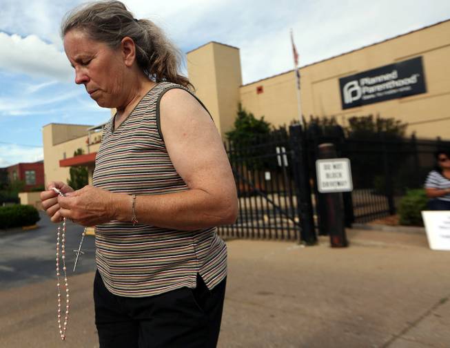 Mary Roy, of Potosi, Mo., holds a rosary in support of a pro-life rally, Tuesday, July 21, 2015, outside a Planned Parenthood building in St. Louis. Anti-abortion activists on Tuesday released a second undercover video aimed at discrediting Planned Parenthood's procedures for providing fetal tissue to researchers. 