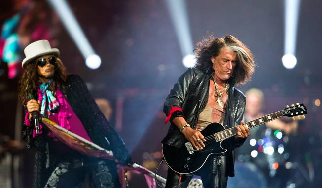 Aerosmith lead singer Steven Tyler watches as lead guitarist Joe Perry performs a guitar solo Saturday, Aug. 1, 2015, at MGM Grand Garden Arena.
