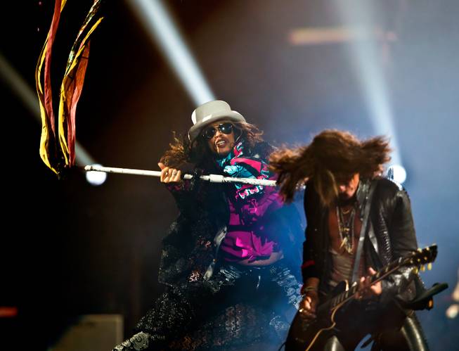 Aerosmith lead singer Steven Tyler spins a mic stand near lead guitarist Joe Perry Saturday, Aug. 1, 2015, at MGM Grand Garden Arena.