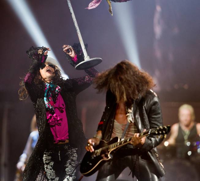 Aerosmith lead singer Steven Tyler tosses a mic stand near lead guitarist Joe Perry Saturday, Aug. 1, 2015, at MGM Grand Garden Arena.