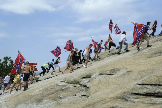Confederate flag supporters climb Stone Mountain to protest of what they believe is an attack on their Southern heritage during a rally at Stone Mountain Park in Stone Mountain, Ga., on Saturday, Aug. 1, 2015. 