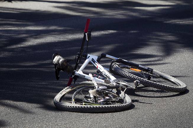 A damaged bicycle is shown on the roadway as Metro Police investigate an accident involving a car and bicycle on the Las Vegas Strip in front of the Treasure Island Aug. 3, 2015. The southbound lanes of Las Vegas Boulevard in front of Treasure Island are closed during the investigation.