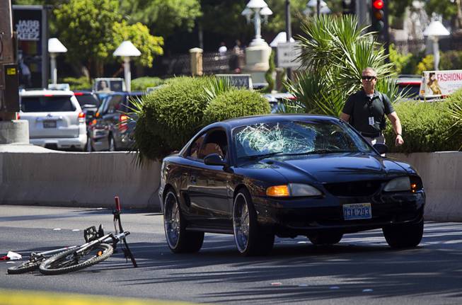 A Metro investigator walks by an accident scene involving a car and bicycle on the Las Vegas Strip on Monday, Aug. 3, 2015, in front of Treasure Island. The southbound lanes of Las Vegas Boulevard in front of T.I. were closed during the investigation.