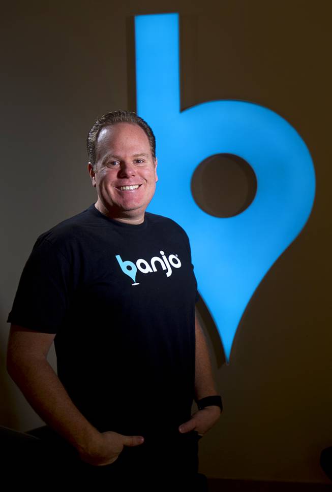 Banjo CEO Damien Patton poses by the company's logo Thursday, Aug. 6, 2015.