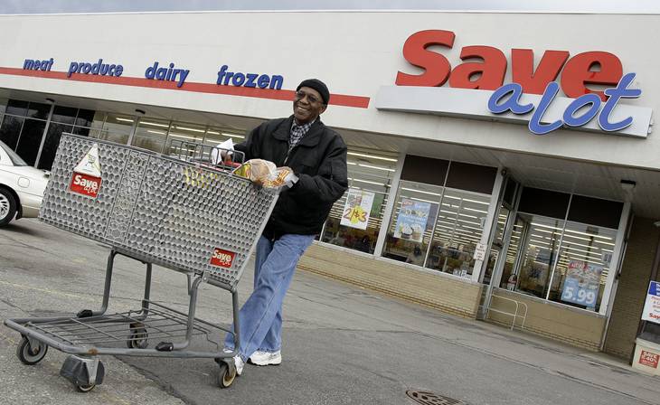 In this April 12, 2011, photo, shopper Andrew Boston leaves the Save-A-Lot grocery store with his purchases in Northfield, Ohio. 