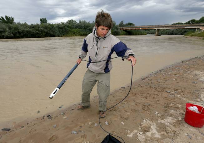Ben Brown, with the Utah Department of Environmental Quality, takes a pH level reading from a probe in the San Juan River on Tuesday, Aug. 11, 2015, in Montezuma Creek, Utah. 