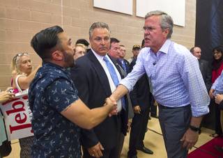 Republican presidential candidate former Florida Gov. Jeb Bush, right, shakes hands with activist A.J. Buhay at the end of a town hall meeting at the Pearson Community Center in North Las Vegas Wednesday, Aug. 12, 2015. Activists disrupted the end of the meeting with chants of 