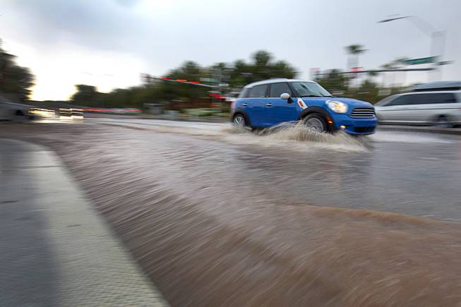 Flood runoff pours into a storm drain on Sunset Road at Whitney Ranch Drive during a thunderstorm Thursday, Aug. 13, 2015, in Henderson.