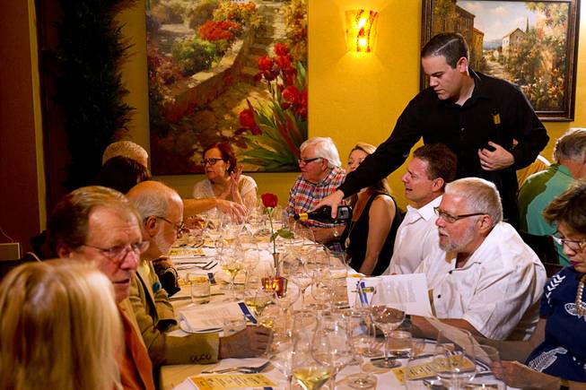 A server pours wine for a table during a Taste & Learn wine event at Ferraro's Italian Restaurant & Wine Bar, 4480 Paradise Rd., Saturday, Aug. 22, 2015.