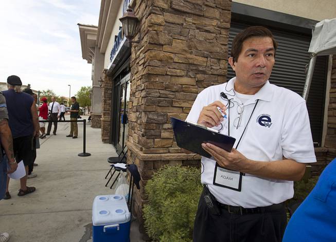 Employee Adam Raphael assists medical marijuana patients as they wait in line during the public opening of Euphoria Wellness, 7785 S. Jones Blvd., the first marijuana dispensary in Las Vegas, Wednesday, Aug. 26, 2015. An opening on Monday was only available to preregistered patients.