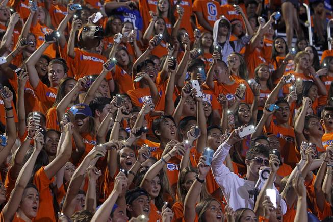 Bishop Gorman High School students hold up their phones during a game against Chandler (Ariz.) High School at Bishop Gorman Saturday, Aug. 29, 2015. Bishop Gorman beat Chandler 35-14.
