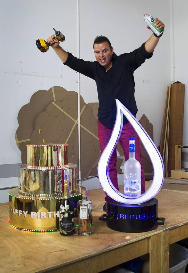 Mike Pampinella, director of All American Design Center, poses in his studio workshop Monday, Aug. 31, 2015. Pampinella creates custom bottle service fabrications for nightclubs. The cake with colored LEDs was made for Omnia. The illuminated water drop bottle presentation, right, was created for Wet Republic.