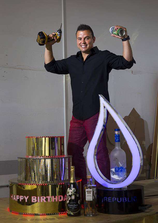 Mike Pampinella, director of All American Design Center, poses in his studio workshop Monday, Aug. 31, 2015. Pampinella creates custom bottle service fabrications for nightclubs. The cake with colored LEDs was made for Omnia. The illuminated water drop bottle presentation, right, was created for Wet Republic.