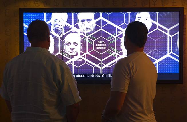 Visitors watch a video at a new exhibit on the FIFA scandal at the The Mob Museum, the National Museum of Organized Crime and Law Enforcement in downtown Las Vegas Tuesday, Sept. 1, 2015.