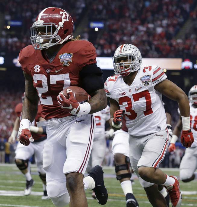 Alabama running back Derrick Henry (27) runs toward the end zone against Ohio State linebacker Joshua Perry (37) in the first half of the Sugar Bowl NCAA college football playoff semifinal game, Thursday, Jan. 1, 2015, in New Orleans. Henry scored a touchdown on the play.
