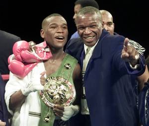 Floyd Mayweather, left, of Grand Rapids, Mich., stands in the ring with his father, Floyd Mayweather Sr., after defeating Diego Corrales of Sacramento, Calif., in their WBC super featherweight championship fight in Las Vegas, in this Jan. 20, 2001 file photo. 