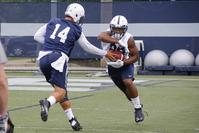 Penn State quarterback Christian Hackenberg (14) hands off to running back Akeel Lynch (22) during an NCAA college football practice, Thursday, Aug. 6, 2015, in State College, Pa.