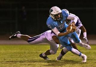 Foothill quarterback Devon Mueller, 5, escapes a sack and turns it into positive yards in a game against Silverado on Friday, Sept. 4, 2015.