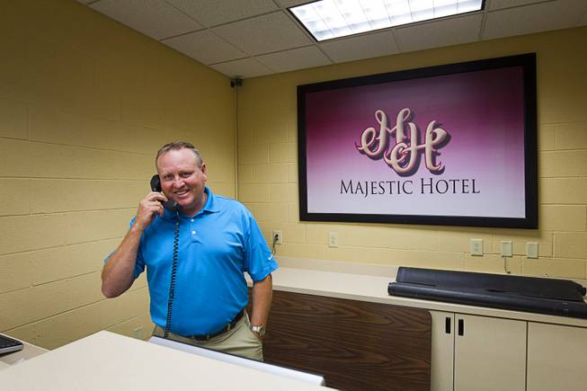 Principal Ken Higbee poses behind the desk of the "Majestic Hotel" during a tour of C.O. Bastian High School in Caliente, Nev., about 150 miles north of Las Vegas,Tuesday, Sept. 8, 2015. The hotel is part of the school hospitality training program. The Lincoln County school, which serves teens in the Caliente Youth Center, boasts a variety of vocational services.