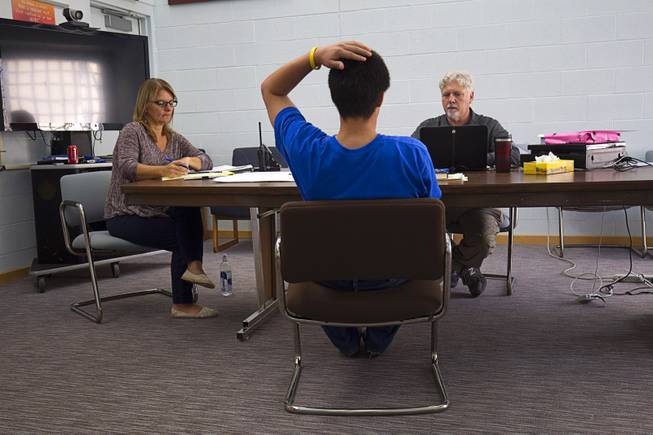 Psychiatrist Norton Roitman listens to a teen during a clinic at the Caliente Youth Center in Caliente, Nev., about 150 miles north of Las Vegas,Tuesday, Sept. 8, 2015. Shana Loveday, a mental health counselor, takes notes at left.
