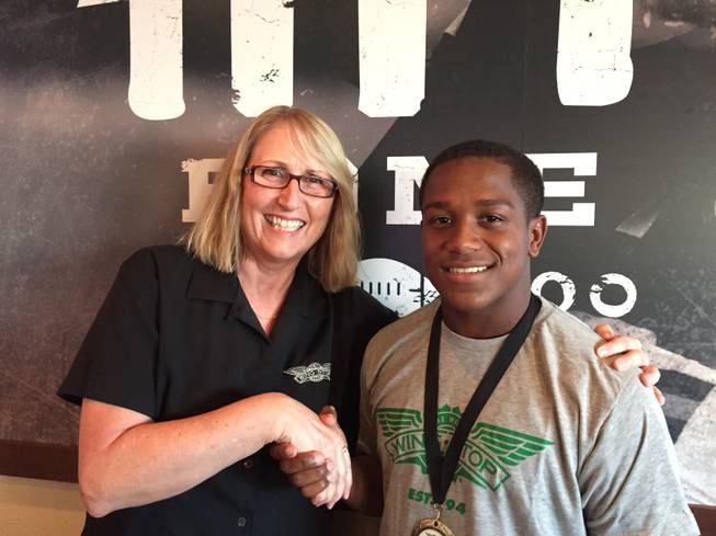 Desert Oasis High running back Tyshun McClinton is pictured with Deb Grant, the Las Vegas Area District Manager for Wingstop.