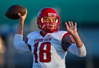 Arbor View QB Hayden Bollinger, 18, readies to fire a pass in the fading light as his team warms up to face Green Valley during high school football on Friday, September 11, 2015.