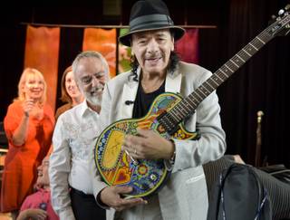 Carlos Santana visits and makes donations of musical instruments at Opportunity Village on Tuesday, Sept. 15, 2015, in Las Vegas. Alberto Kreimerman, CEO of Hermes Music, is at left.
