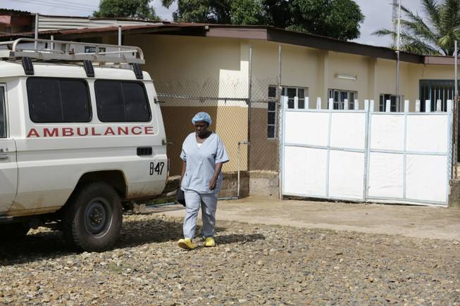 A nurse walks past an ambulance Monday, Aug. 10, 2015, at a clinic shared by U.S. epidemic research firm Metabiota Inc. and international researchers at the government hospital in Kenema, eastern Sierra Leone. The San Francisco-based startup Metabiota had been charged with reinforcing Sierra Leone's response to Ebola, but emails obtained by the AP alleged that the company was undermining the U.N. agency's authority by drawing up response plans without WHO's knowledge.