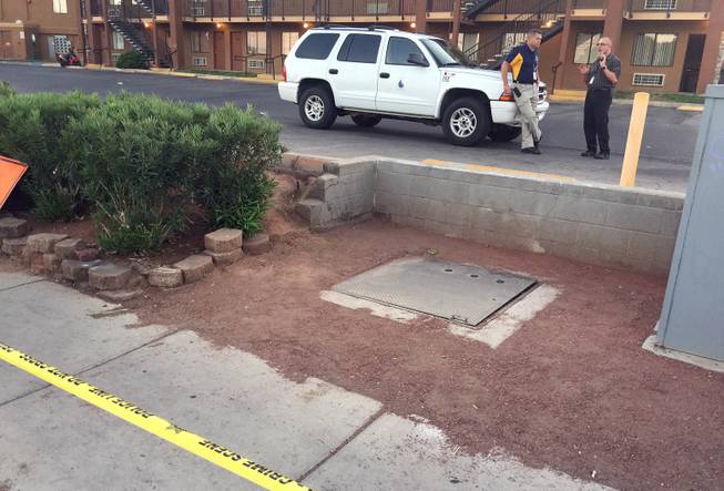 The metal cover of a utility vault is shown Tuesday, Sept. 22, 2015, outside a complex of extended-stay suites on Boulder Highway. A duffle bag containing human remains was discovered inside the vault.
