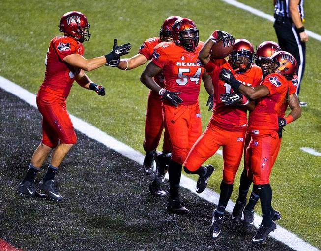 UNLV 's Tim Hough, 13, is congratulated in the end zone taking back an interception for a score after teammate Kenny Keys, 44, deflected a pass intended for Idaho State's Josh Cook, 11, late in their game at Sam Boyd Stadium on Saturday, September 26, 2015.