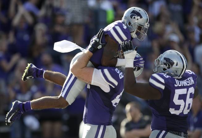 Kansas State wide receiver Dominique Heath (4) celebrates a touchdown with teammates Luke Hayes (68) and Terrale Johnson (56) during overtime of an NCAA college football game against Louisiana Tech in Manhattan, Kan., Saturday, Sept. 19, 2015. Kansas State defeated Louisiana Tech 39-33 in triple overtime.