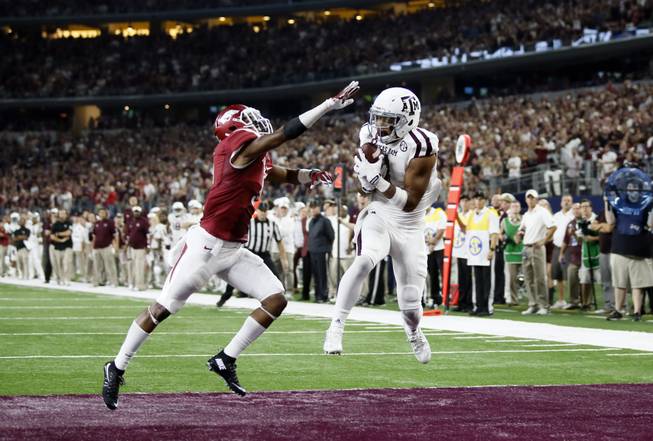 Texas A&M wide receiver Christian Kirk, right, pulls in a pass for a touchdown as Arkansas defensive back Henre' Toliver (5) defends in overtime of an NCAA college football game on Saturday, Sept. 26, 2015, in Arlington, Texas. The Aggies won 28-21.