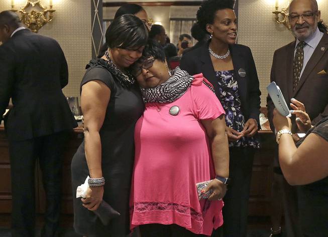 Plaintiffs Lisa Johnson, left, hugs Deborah Neal before a news conference announcing the filing a lawsuit over their ejection from a Napa Valley Wine Train, Thursday, Oct. 1, 2015, in San Francisco. A group of mostly black women who were ejected from a Northern California wine country train this summer say they felt humiliated and can't believe they were treated that way in 2015.