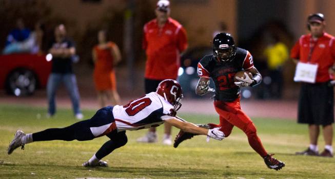 Coronado High School's , 30, dives towards Las Vegas' Diquan Brown, 25, who evades the tackle and turns up field during their football game on Friday, December 02, 2015.
