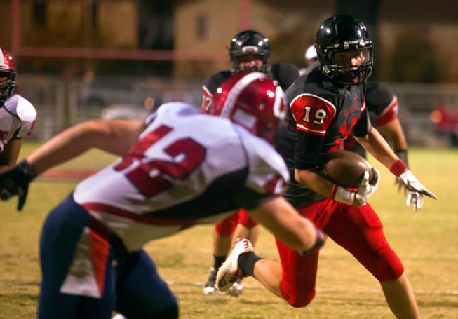 Las Vegas High School's Kevin Smith, 19, looks to avoid a tackle near the goal line by Coronado's Jackson Strong, 42,  during their football game on Friday, December 02, 2015.