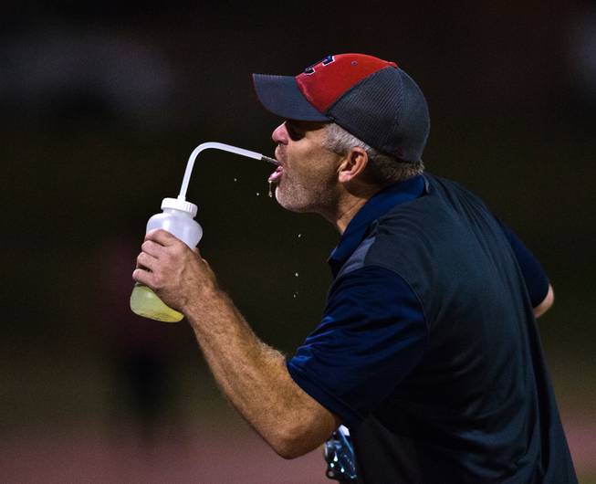 Coronado head coach William Froman grabs a drink after a tough night on the sidelines losing their football game big to Las Vegas on Friday, December 02, 2015.