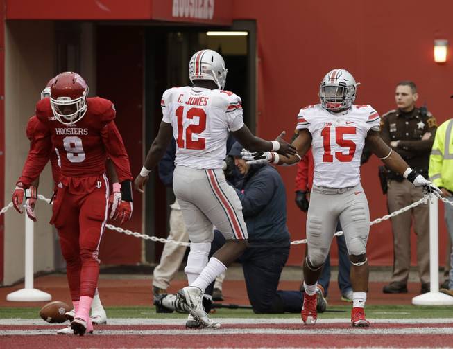 Ohio State's Ezekiel Elliott (15) celebrates with Cardale Jones (12) after Elliott ran 55 yards for a touchdown. Indiana's Jonathan Crawford (9) is at left.