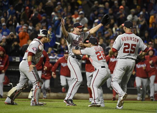 Washington Nationals starting pitcher Max Scherzer, second from left, celebrates his no hitter against the New York Mets with teammates, catcher Wilson Ramos (40), Dan Uggla (26), and Clint Robinson (25) in the second baseball game of a doubleheader, Saturday, Oct. 3, 2015, in New York. The Nationals won 2-0