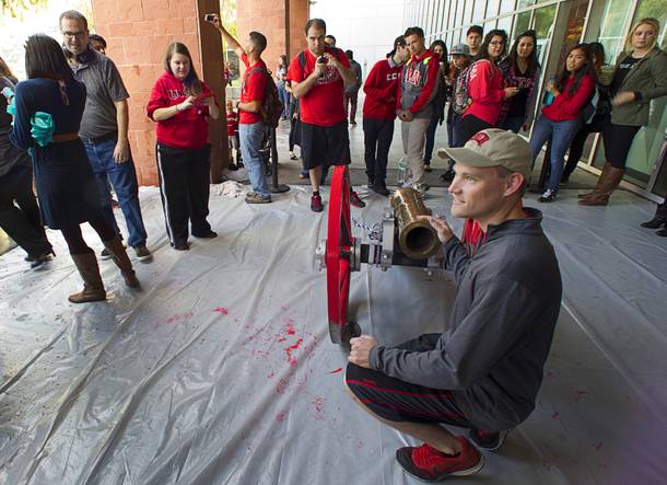 UNLV alumni Chris Clifton kneels by the Fremont Cannon during a cannon-painting ceremony Monday, Oct. 5, 2015, at UNLV. The Rebels recovered the Fremont Cannon after defeating the Wolfpack 23-17 on Saturday in Reno.