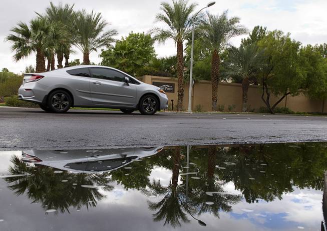 A car is reflected in a puddle on Wigwam Parkway after a rain stormed moved through Henderson on Monday, Oct. 5, 2015.