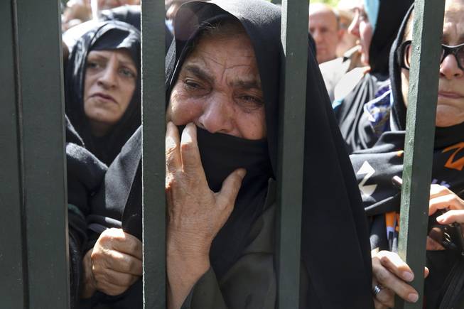 In this Sunday, Oct. 4, 2015, file photo, an Iranian mourner weeps during a funeral ceremony, attended by thousands of mourners in Tehran, Iran, for some of the pilgrims who were killed in a stampede during the hajj pilgrimage in Saudi Arabia in September 2015.